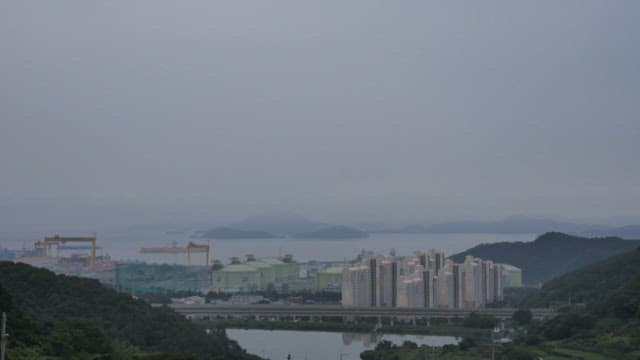 Day to night view of a city with buildings and the sea