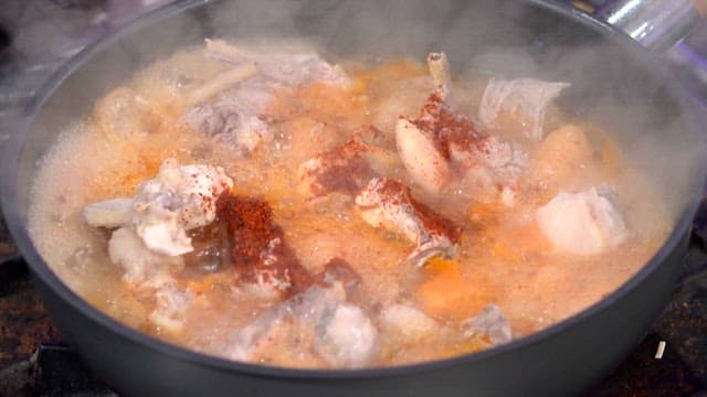 Spicy seasoned chicken boiling in a pot