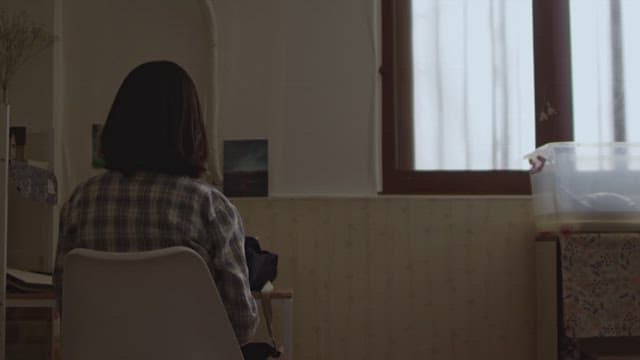 Woman sitting at a desk in a dimly lit room