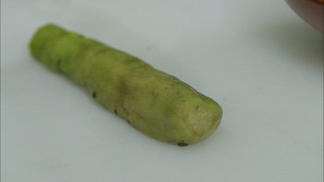 Slicing a cooked eggplant on a cutting board
