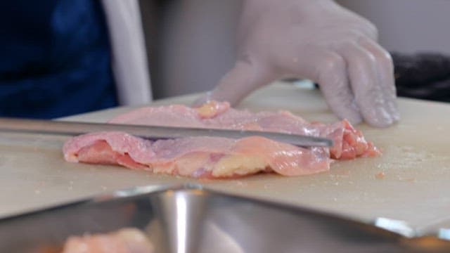Person chopping chicken
