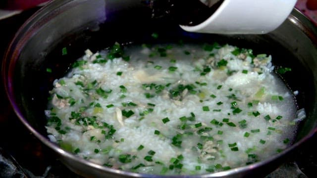 Korean porridge with seaweed being put in a pot