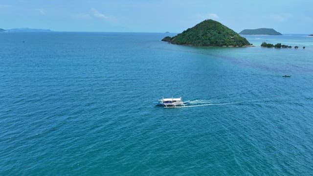 Bangka boat sailing near lush green islands