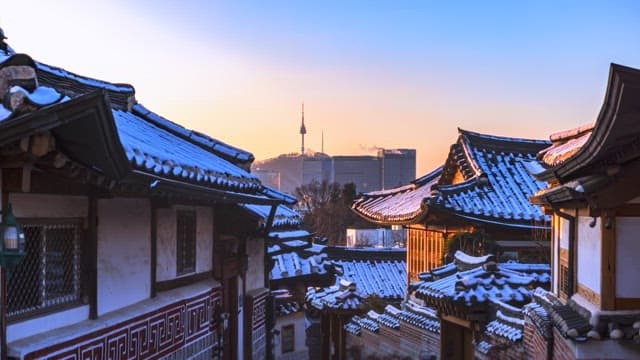 Snow-covered Bukchon Hanok Village in the city at sunset
