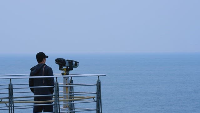 Man Overlooking the Sea from a Viewpoint