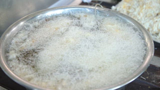 Cooking fish fritters by putting batter coated in boiling oil