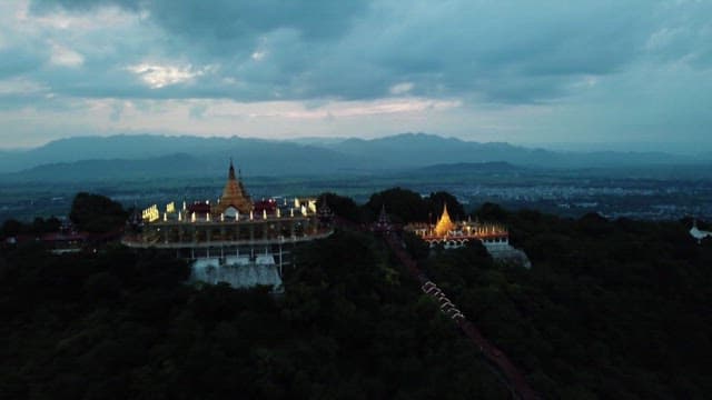 Illuminated Temple Overlooking a Scenic Landscape at Dusk