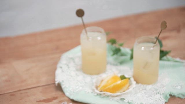 Two Sweet Korean Melon Juice Glasses with Melon Slices on a Wooden Table