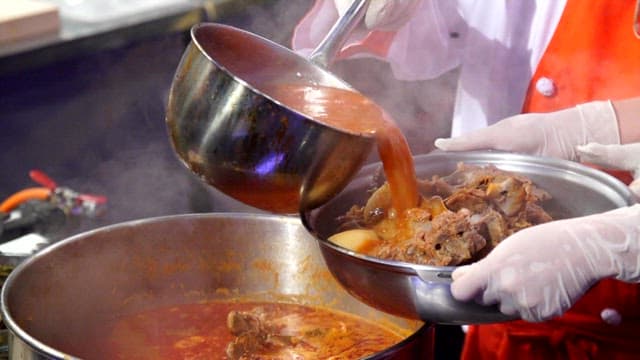 Putting seasoning broth in a pot with pork backbone