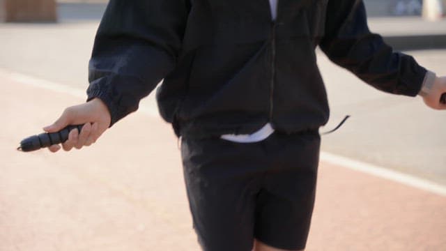 Person skipping rope outdoors