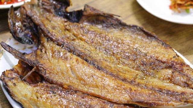 Grilled mackerel served on a white plate