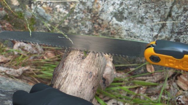 Cutting a log with a saw outdoors