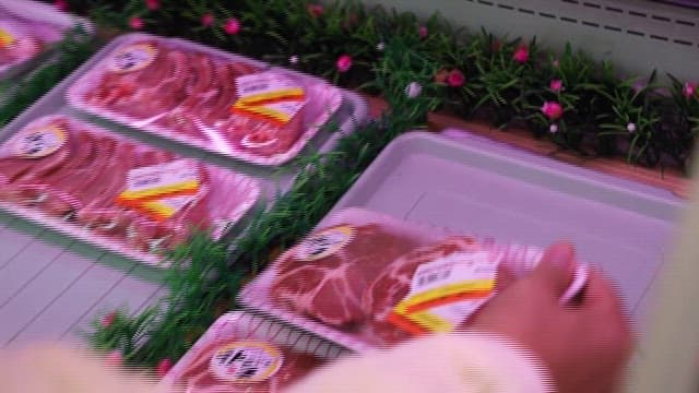Picking Pork Meat Packs in Grocery Store