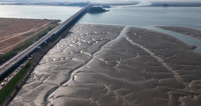 Bridge over a vast mudflat and sea