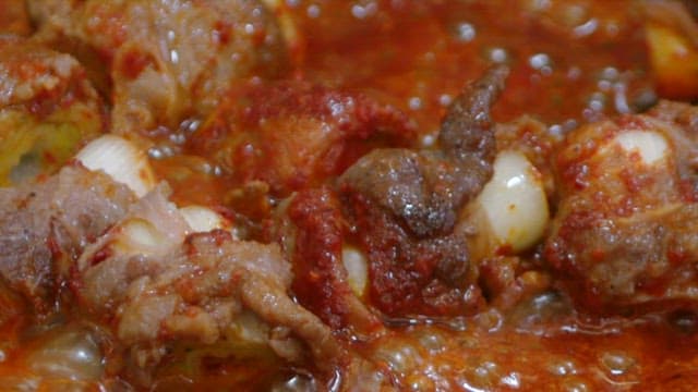 Green onion beef rolls cooking in a pan