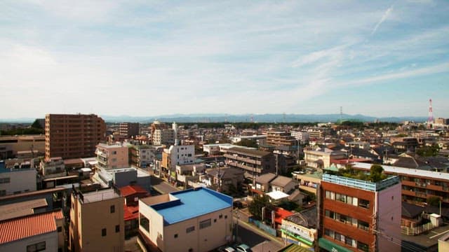Early morning cityscape with residential buildings and distant mountains.