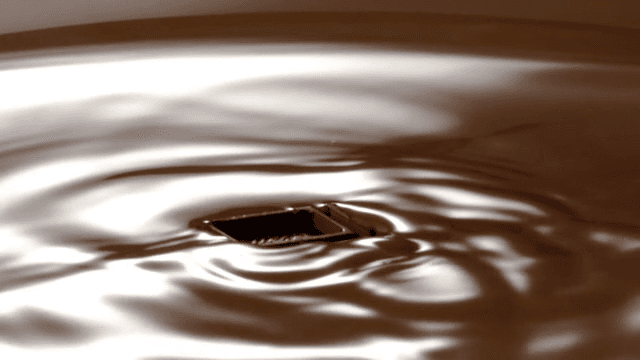 Chocolate pieces falling into chocolate fondue