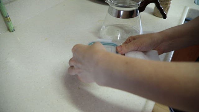 Picking up boswellia from a plastic container in the kitchen