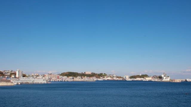 Wide View of a Coastal Village and Port under Clear Blue Sky