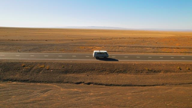 Van Traveling Across Vast Desert Road