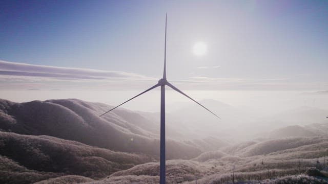 Wind Generators on Misty and Snowy Mountain in the Morning