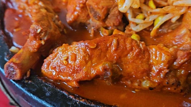 Spicy braised pork ribs with bean sprouts on a hot plate