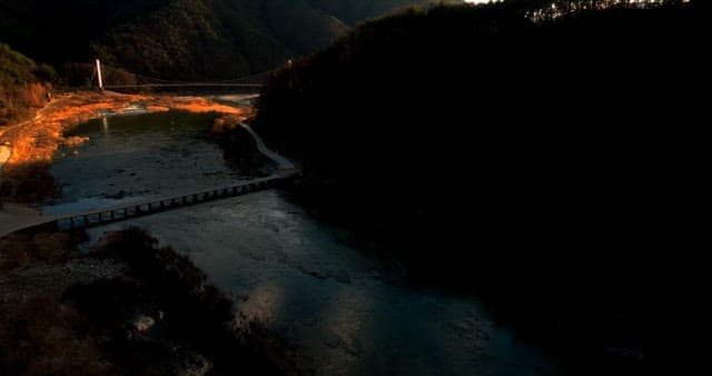 Sunset Over a Mountainous Suspension Bridge