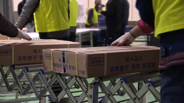 People Moving Boxes of Packed CSAT Question Papers