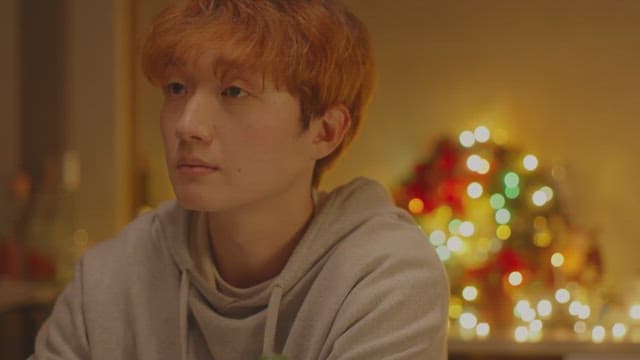 Man feeling depressed in a room decorated with Christmas lights
