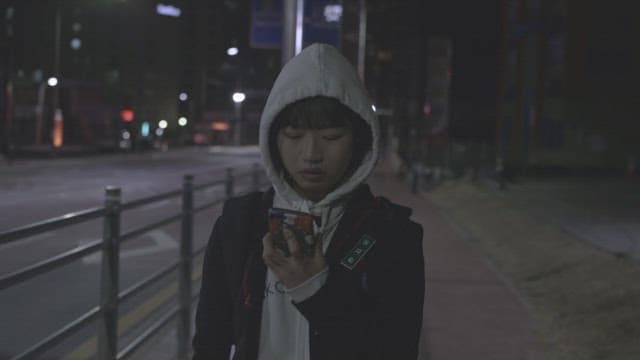 Girl walking alone on a dimly lit street at night