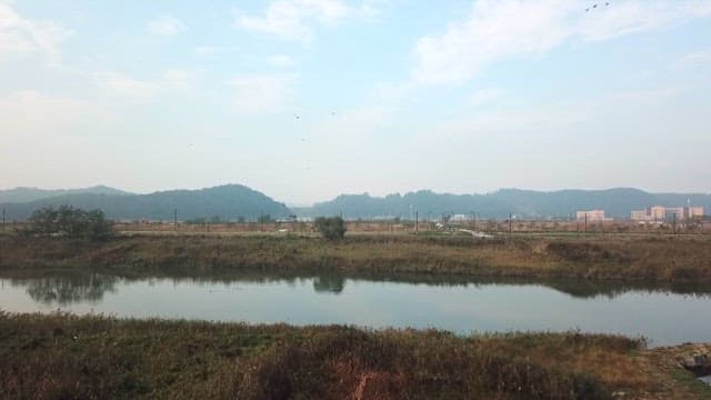 Quiet riverside in the countryside with distant mountains in view