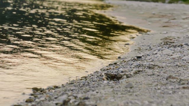 Gentle waves touching the pebble shore at sunset