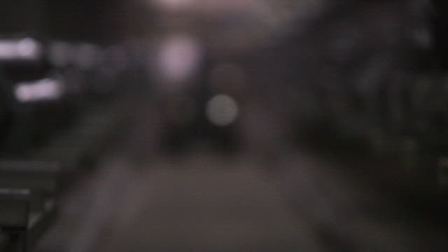 Robot moving through factory aisle with with large pipes