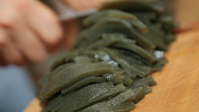 Cutting seaweed jelly on a wooden cutting board