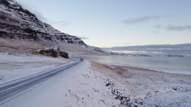 Snowy road by the mountains and sea