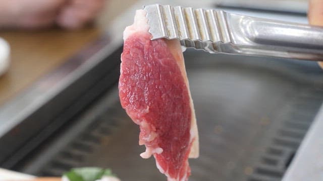 Eating Meat Grilled on a Grill at a Restaurant