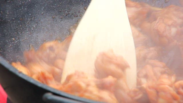 Chicken being stirred in a pan
