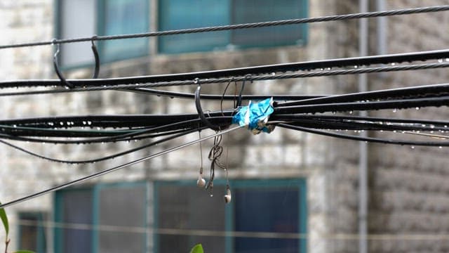 Wet electric cables with tangled earphones on a rainy day