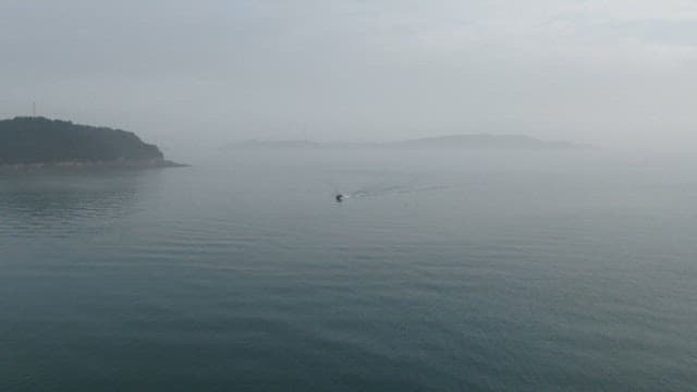Boat Travelling Through Misty Waters