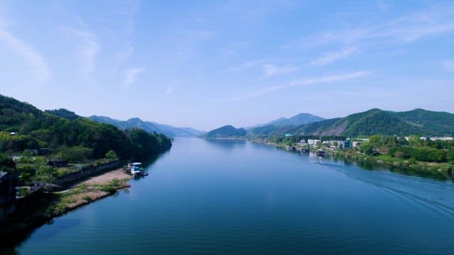 Serene River Flowing Between Lush Hillsides