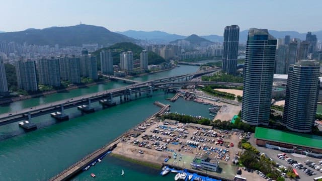 Bustling urban scene with numerous tall buildings and a network of intersecting highways over a ri