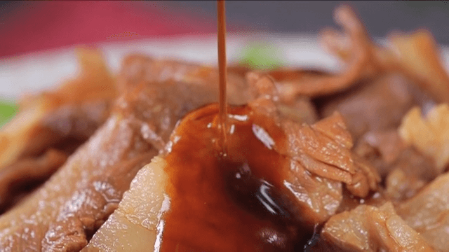 Sauce being poured over cooked meat