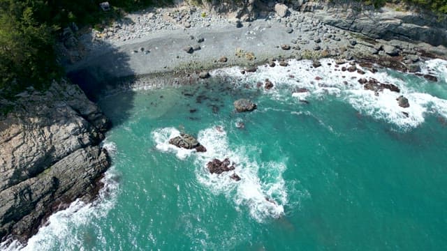 Waves Crashing on the Grey-Brown Rocky Coast
