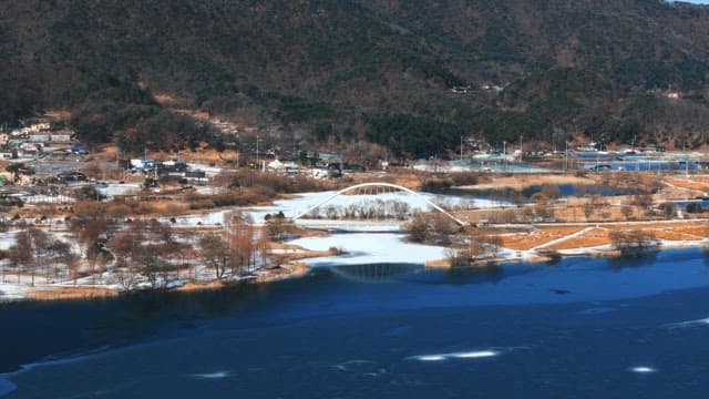 Snowy Landscape with Bridge and Frozen River