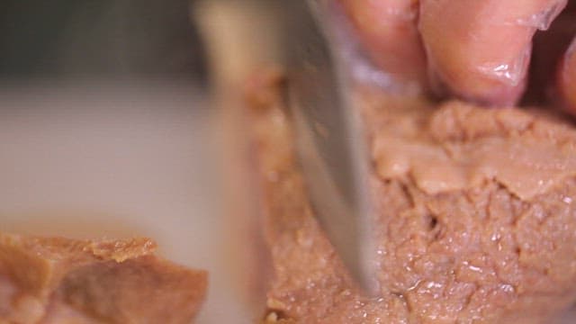 Slicing boiled pork on a cutting board