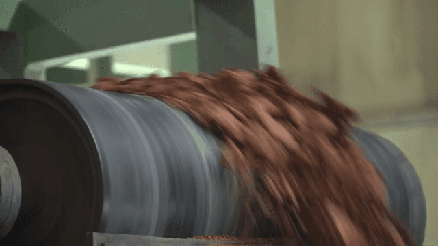 Brown material being processed in a machine