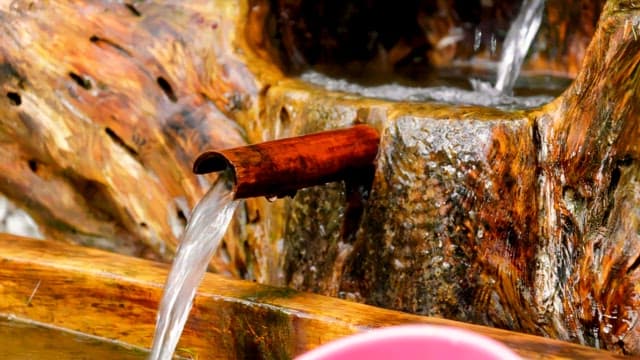 Water flowing into a wooden trough at mineral spring