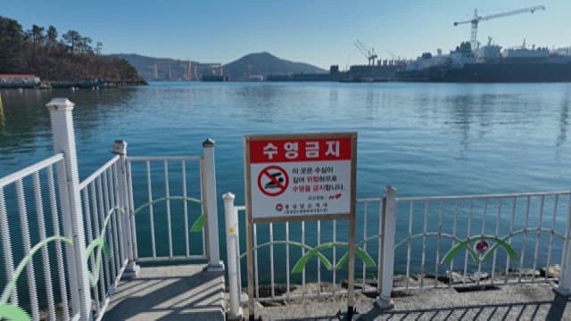 No Swimming Sign Posted on the Coastal Railing