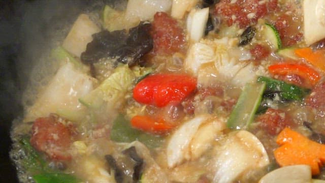 Wok of boiling vegetables and meat