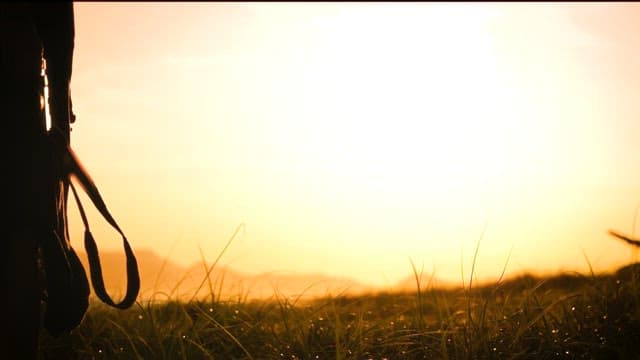 Silhouette of a person with camera at sunset